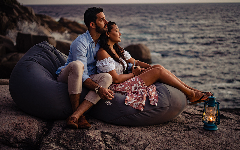Couple Relaxing at Sunset on The Rocks