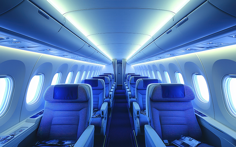 Wide-angle view of a spacious airplane cabin with passengers rel